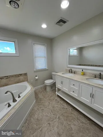 a bathroom with a tub sink and mirror