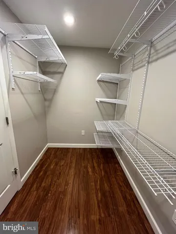 a view of walk in closet with wooden floor