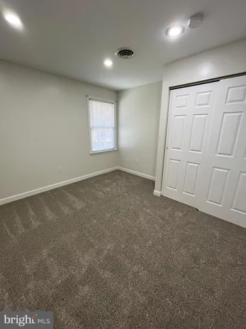 en empty room with windows and chandelier fan