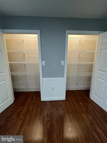 an empty room with wooden floor and door