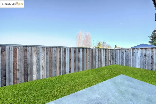 a view of a backyard with wooden fence