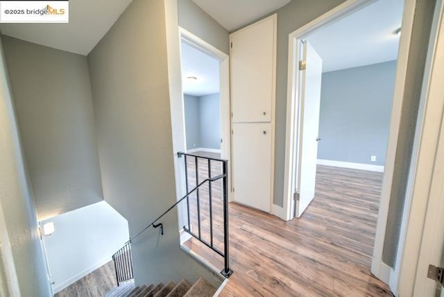 a view of a hallway with wooden floor and staircase