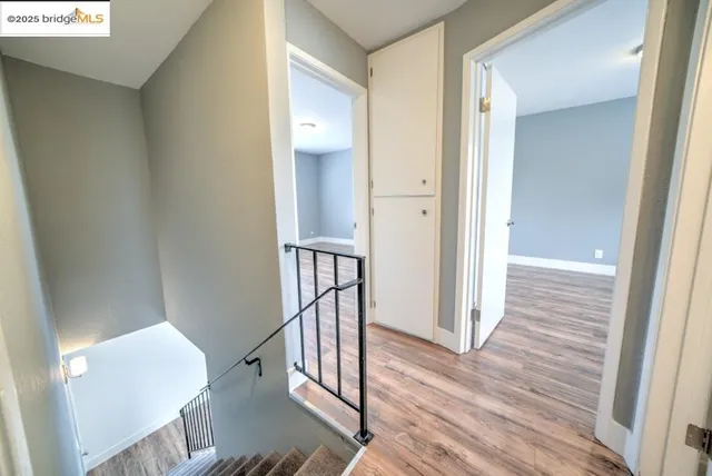 a view of a hallway with wooden floor and staircase