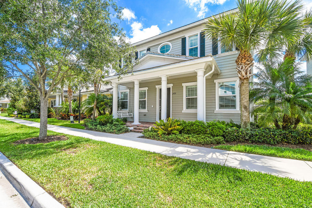 2719 Wymberly Drive Jupiter, FL 33458 - Photo 1 of 49 a front view of a house with a yard and porch