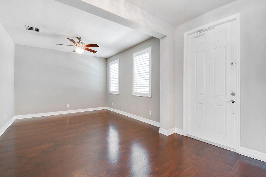 2719 Wymberly Drive Jupiter, FL 33458 - Photo 12 of 49 an empty room with wooden floor and windows