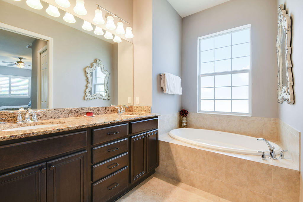 2719 Wymberly Drive Jupiter, FL 33458 - Photo 24 of 49 a bathroom with a tub a sink and a large mirror