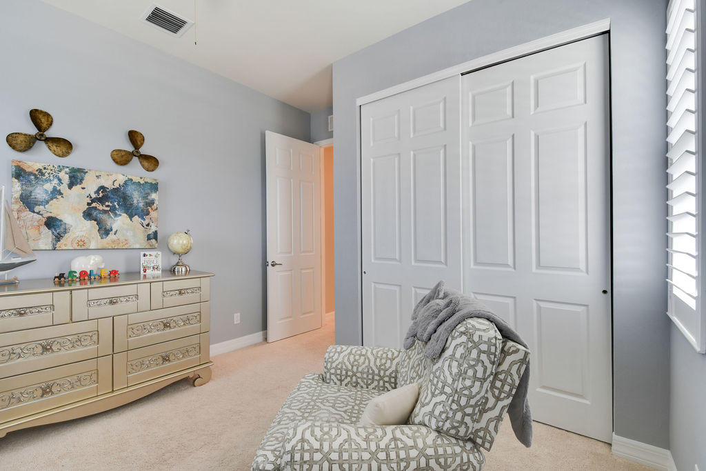 2719 Wymberly Drive Jupiter, FL 33458 - Photo 35 of 49 a bedroom with a bed and a dresser