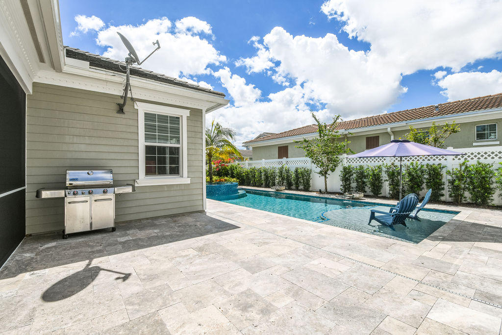 2719 Wymberly Drive Jupiter, FL 33458 - Photo 37 of 49 a view of a chairs and table in backyard of the house