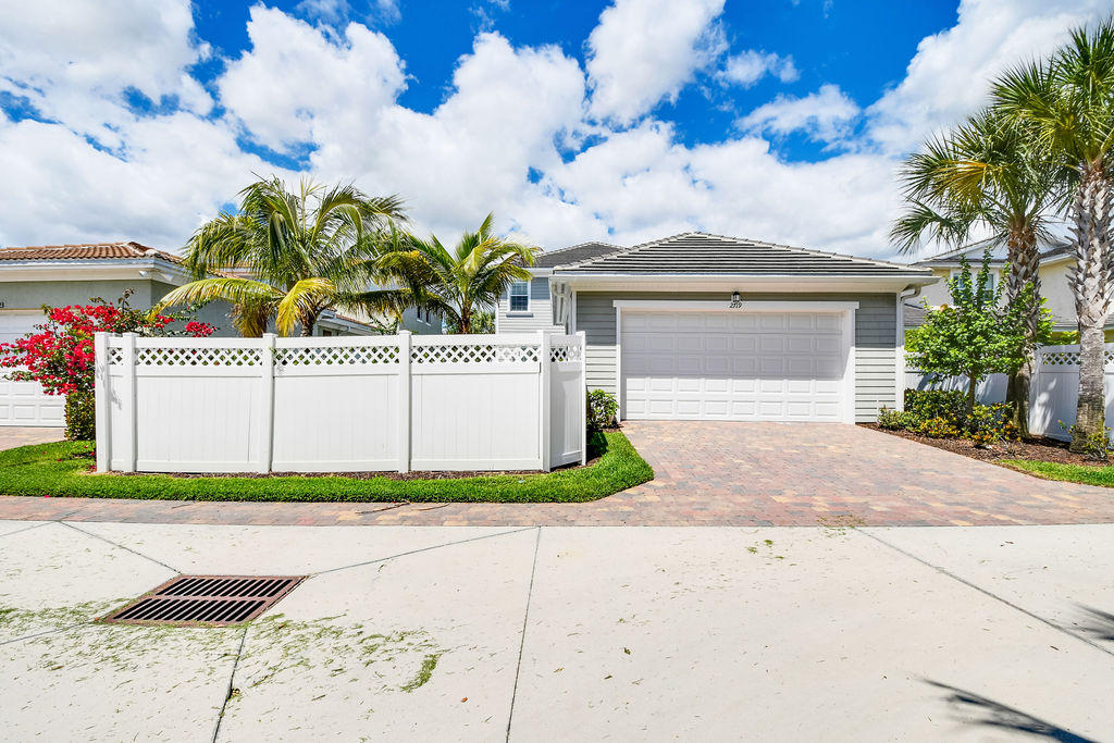 2719 Wymberly Drive Jupiter, FL 33458 - Photo 44 of 49 a front view of a house with a yard and garage
