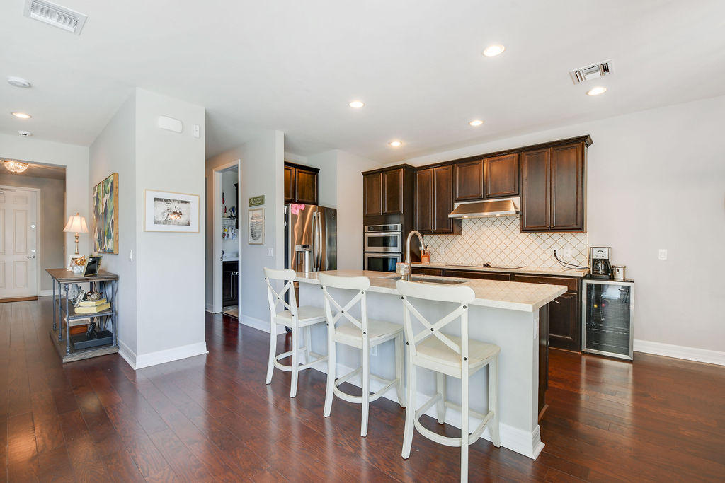 2719 Wymberly Drive Jupiter, FL 33458 - Photo 6 of 49 a kitchen with stainless steel appliances kitchen island granite countertop a refrigerator and a stove top oven