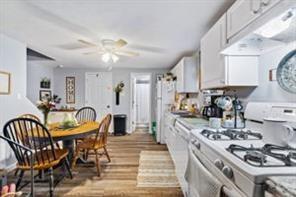 118 Constitution Street Perryopolis, PA 15473 - Photo 19 of 34 a kitchen with stainless steel appliances granite countertop a stove top oven a refrigerator a dining table and chairs with wooden floor