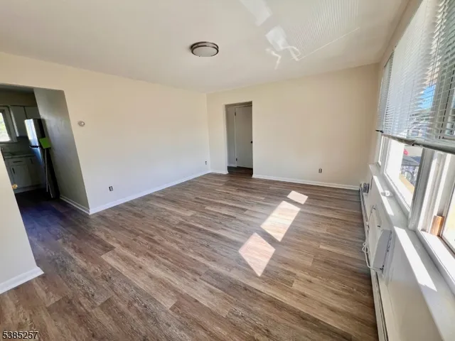 an empty room with wooden floor and entrance
