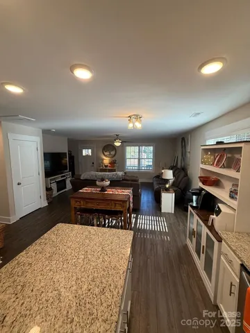 a living room with furniture a flat screen tv and kitchen view