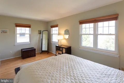 a bedroom with a bed and a window with chair