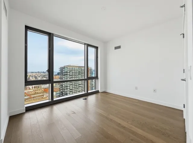 wooden floor in an empty room with a window