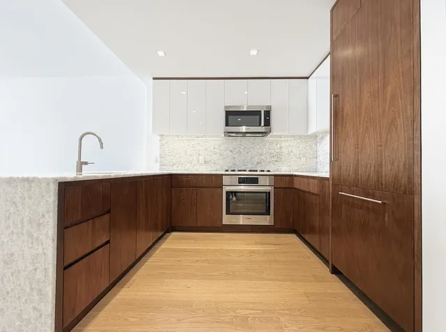 a kitchen with stainless steel appliances kitchen island granite countertop a stove top oven a sink and dishwasher