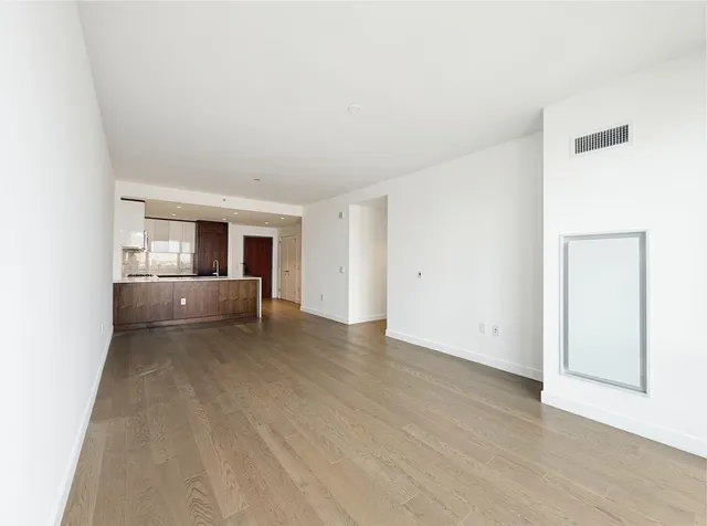 a view of a room with wooden floor and kitchen