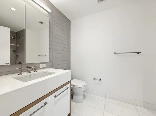 a bathroom with a sink a toilet and a mirror