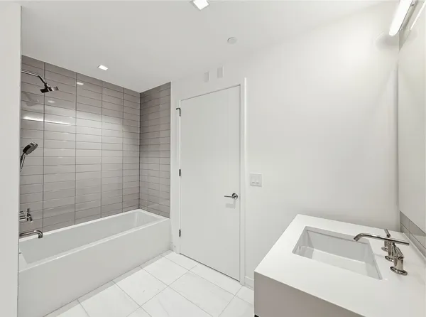 a bathroom with a tub shower and sink
