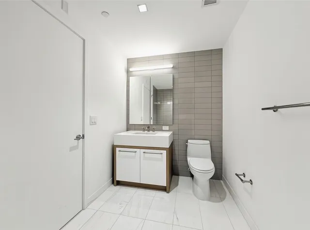 a bathroom with a toilet a sink and mirror