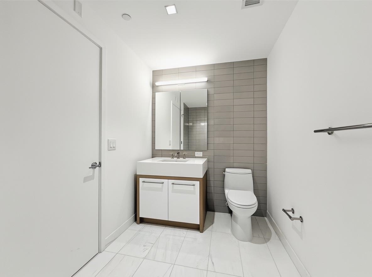 75 Park Lane South, Unit 3202 Jersey City, NJ 07310 - Photo 10 of 40 a bathroom with a toilet a sink and mirror