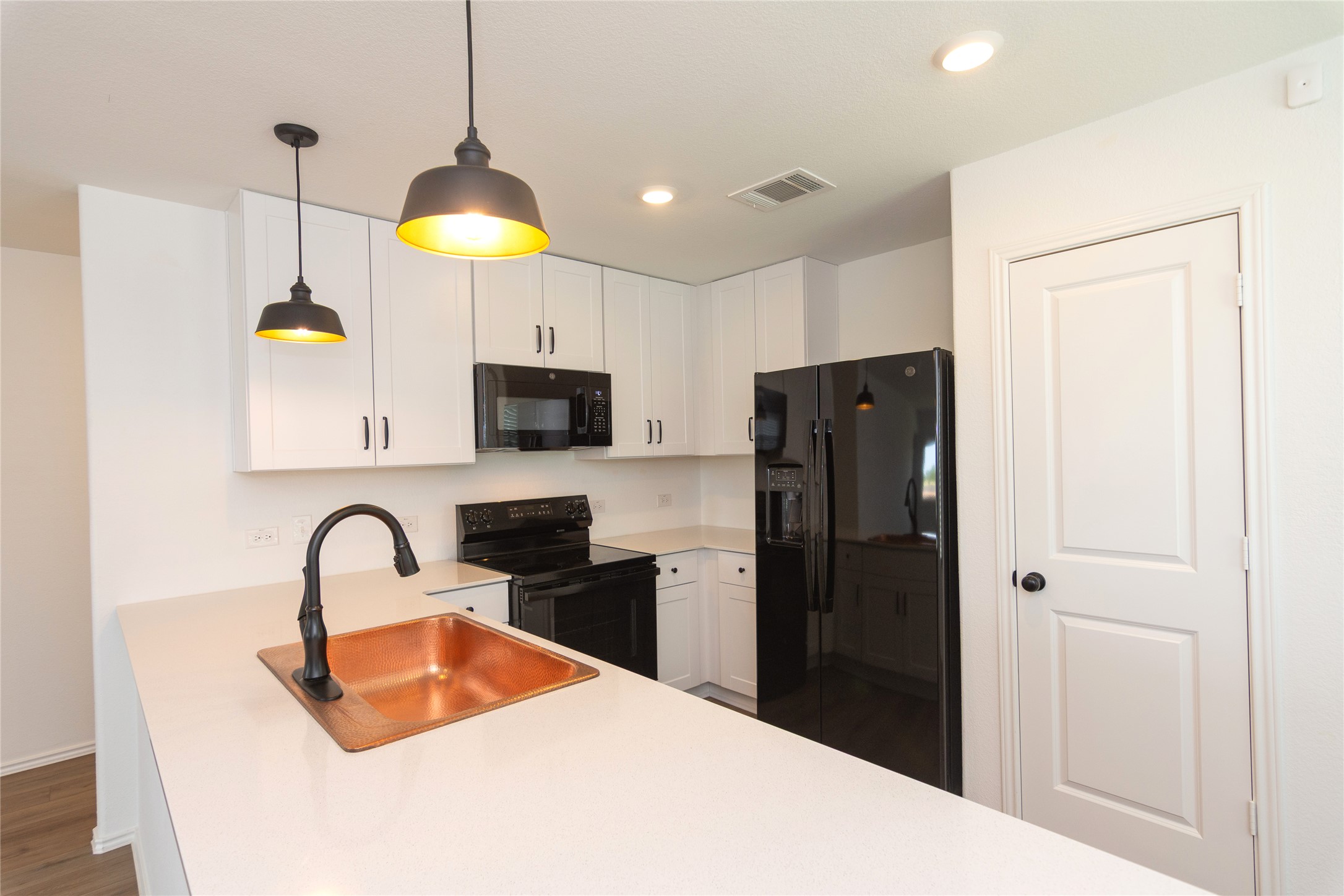 548 Rancho Del Cielo Loop Jarrell, TX 76537 - Photo 6 of 40 Kitchen with white cabinetry, black appliances, a copper sink with a oil-rubbed bronze faucet, and pendant lighting
