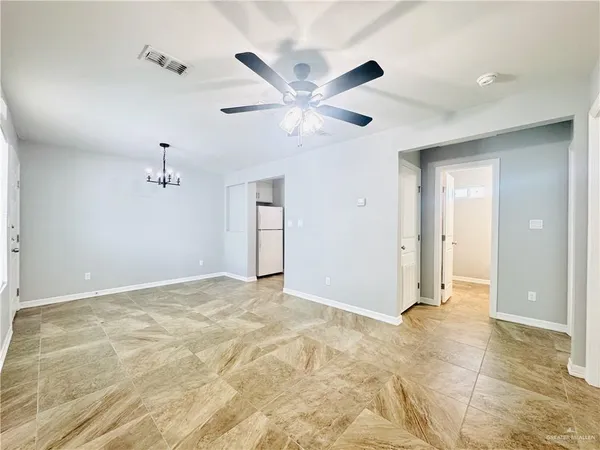 an empty room with a ceiling fan and window