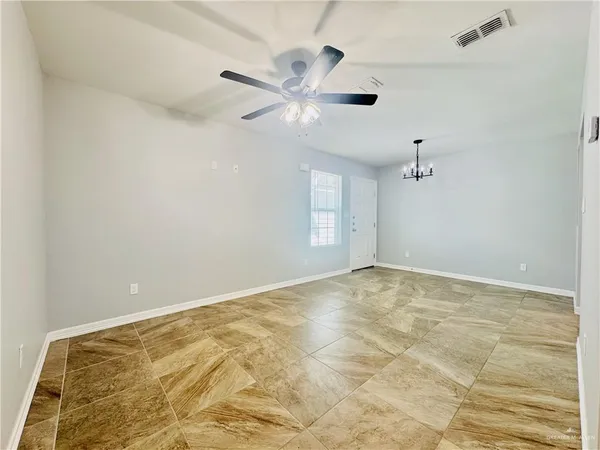 an empty room with fan and windows