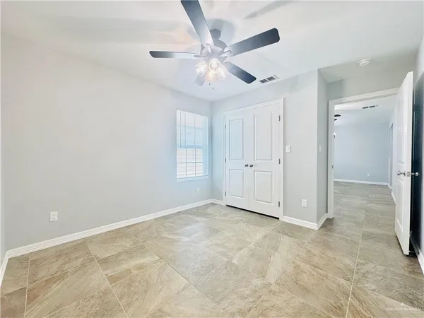 an empty room with window and ceiling fan