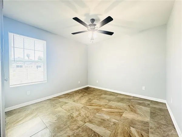 an empty room with fan and windows