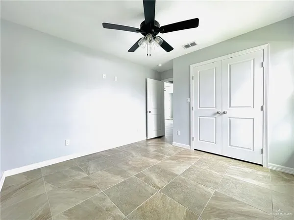 an empty room with fan and windows
