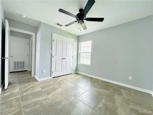 an empty room with a window and a fan