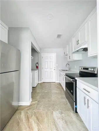 a kitchen with white cabinets and white appliances