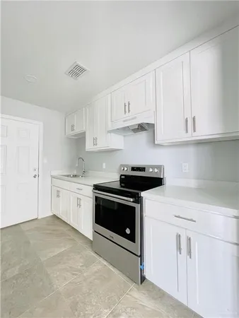 a kitchen with granite countertop white cabinets and white appliances