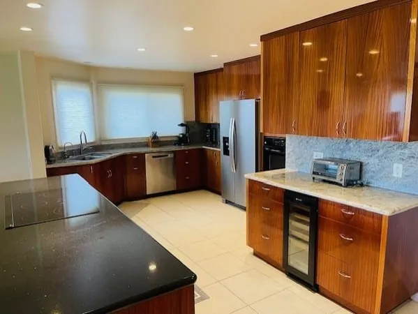 a kitchen with stainless steel appliances granite countertop a sink wooden cabinets and a refrigerator