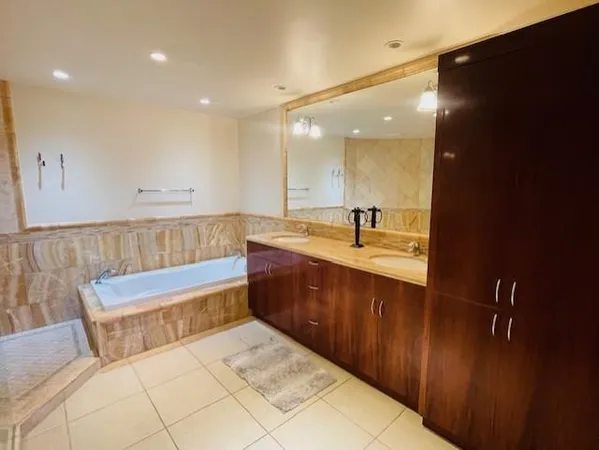 a bathroom with a tub sink and mirror