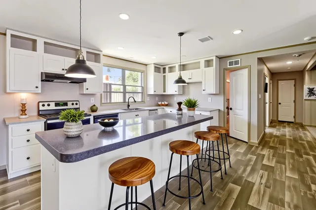 a kitchen with stainless steel appliances granite countertop a kitchen island a stove and a cabinets
