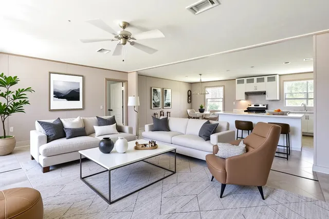 a living room with furniture kitchen view and a chandelier