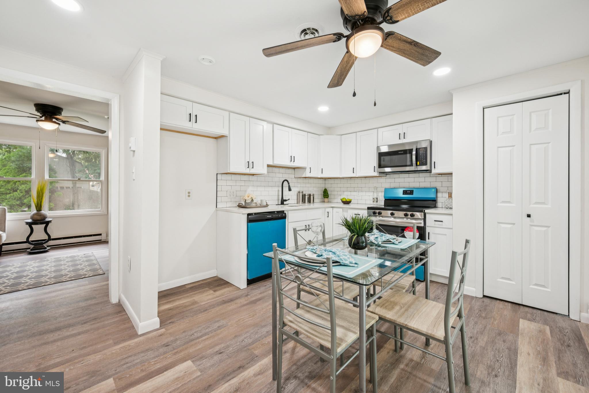 651 Erial Road Sicklerville, NJ 08081 - Photo 7 of 24 a kitchen with stainless steel appliances kitchen island granite countertop a refrigerator a stove top oven a dining table and chairs with wooden floor