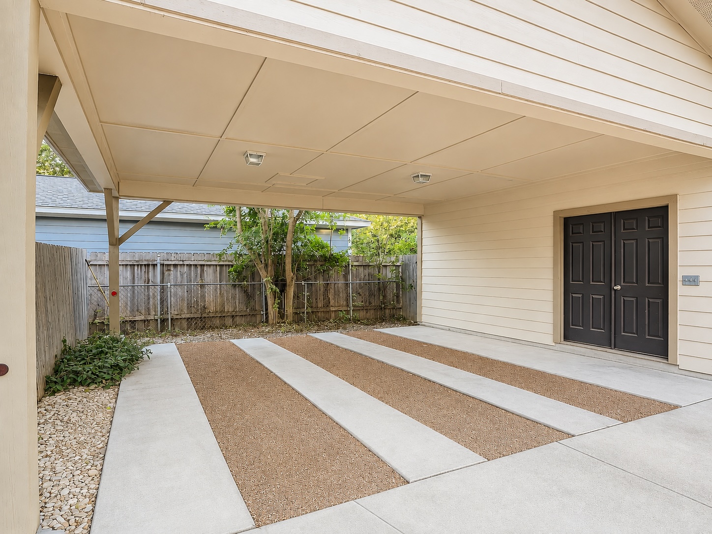 2009 Richcreek Road Austin, TX 78757 - Photo 17 of 23 An attached carport provides protected vehicle parking alongside concrete and gravel paving. And storage space.