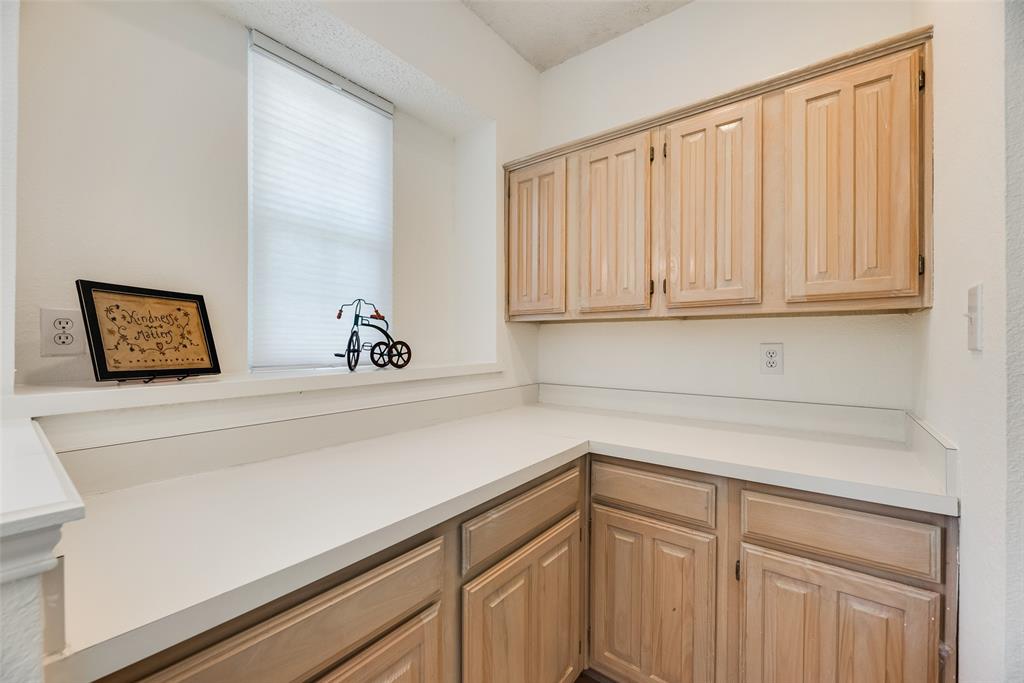 1406 West Peters Colony Road Carrollton, TX 75007 - Photo 25 of 29 a bathroom with a sink and cabinets