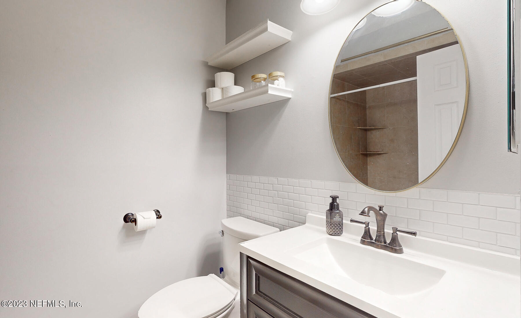 11338 Rustic Pines Circle East Jacksonville, FL 32257 - Photo 25 of 33 a bathroom with a sink vanity mirror and toilet