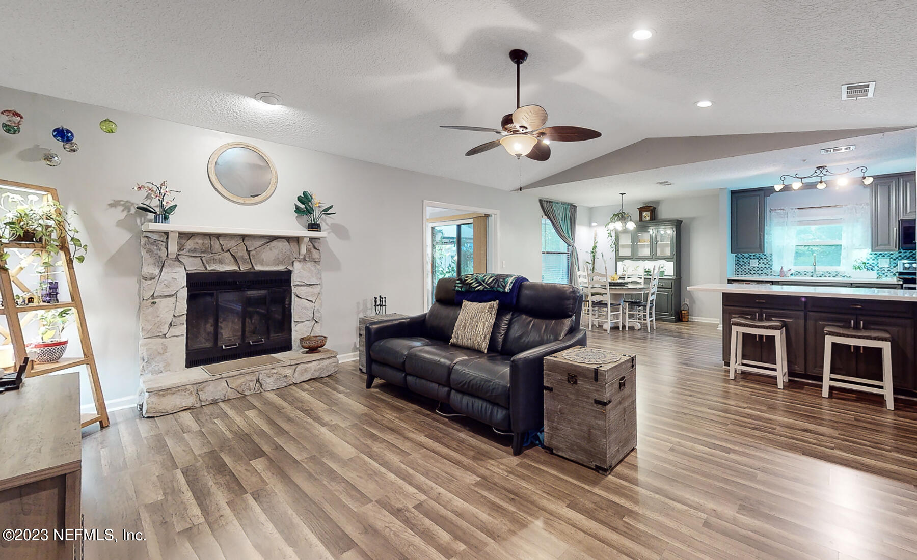 11338 Rustic Pines Circle East Jacksonville, FL 32257 - Photo 4 of 33 a living room with furniture a fireplace and a chandelier