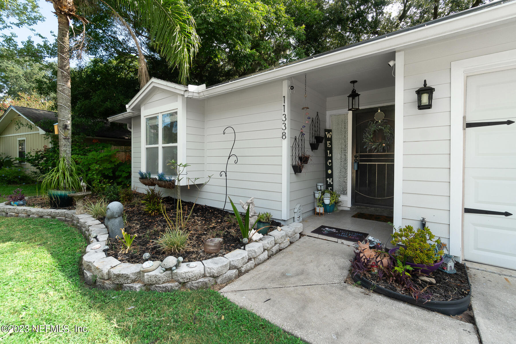 11338 Rustic Pines Circle East Jacksonville, FL 32257 - Photo 7 of 33 a white house with a yard and garden