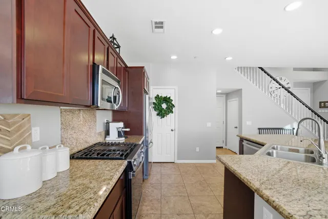a kitchen with granite countertop a sink a stove and cabinets