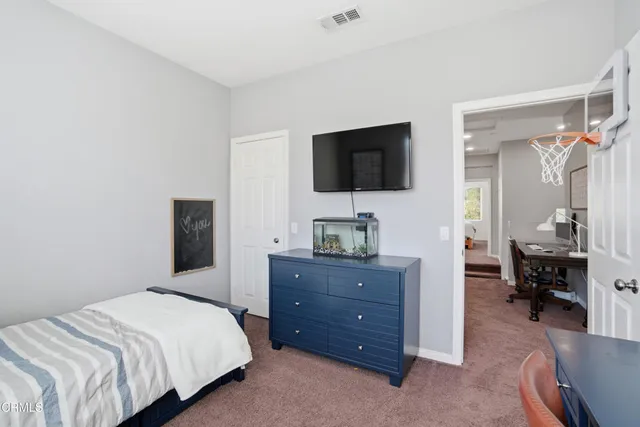 a bedroom with a bed and a flat tv screen on wall
