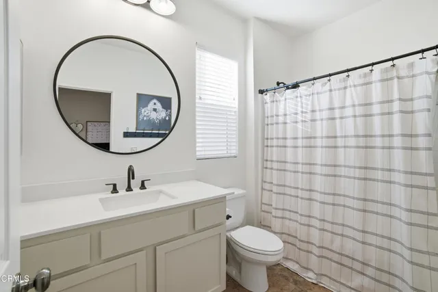 a bathroom with a toilet a sink and a mirror