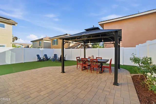 a view of a patio with table and chairs under an umbrella