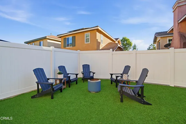 a backyard of a house with table and chairs