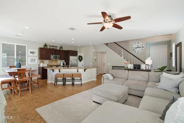 a living room with furniture kitchen view and a chandelier